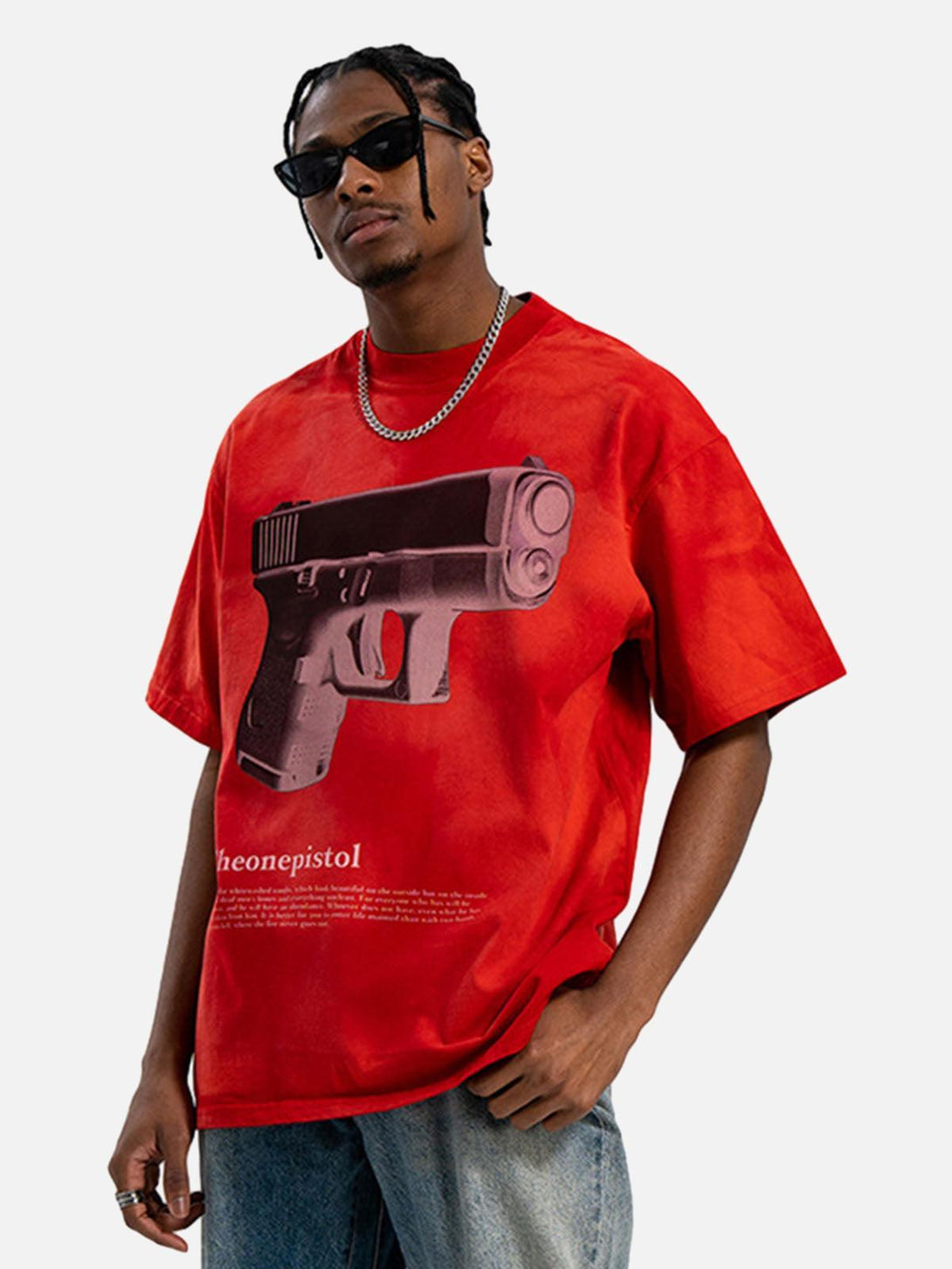 Model in a red graphic T-shirt by TALISHKO, featuring a bold gun print for an urban edge.
