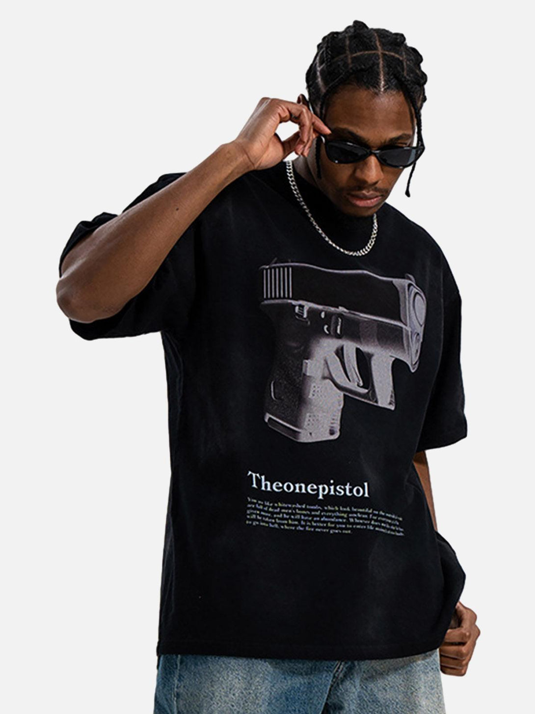 Model wearing a black graphic tee by TALISHKO, featuring a bold gun print for urban flair.