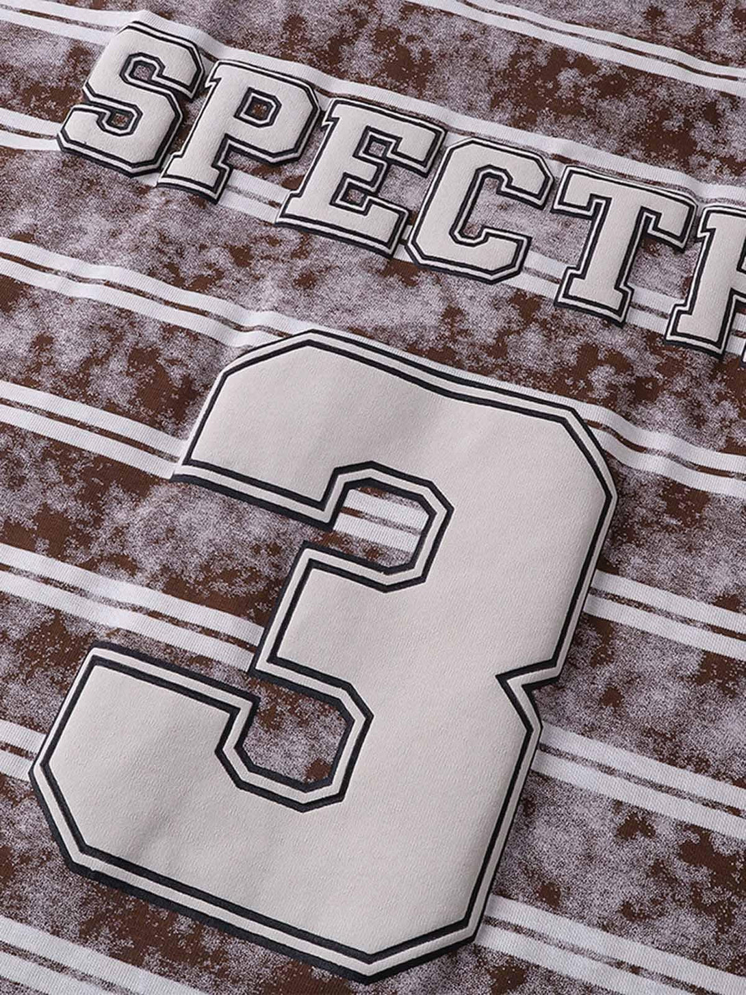 A tight crop highlighting the graphic lettering and number on TALISHKO's striped T-shirt.