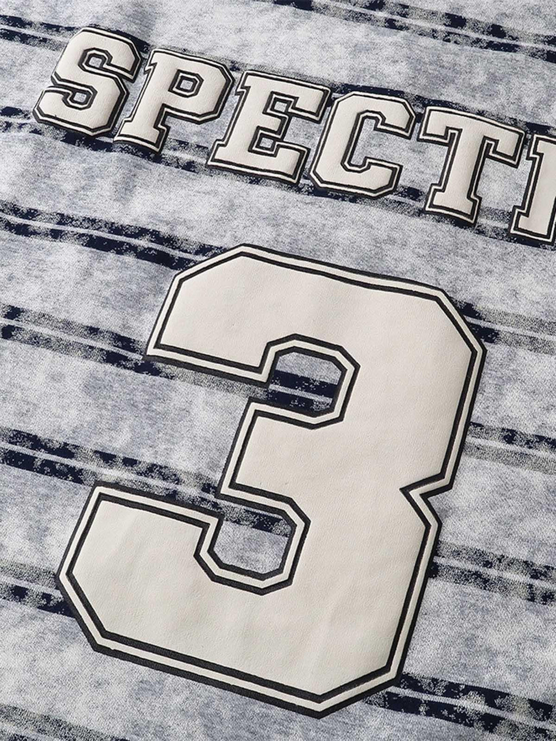 Zoomed-in view of the graphic lettering and number on a striped T-shirt by TALISHKO.