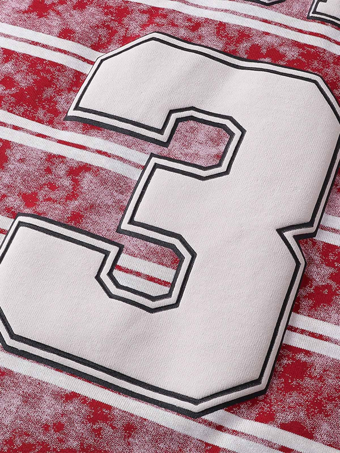 Zoomed-in view of TALISHKO's striped T-shirt, highlighting bold graphic lettering and number.