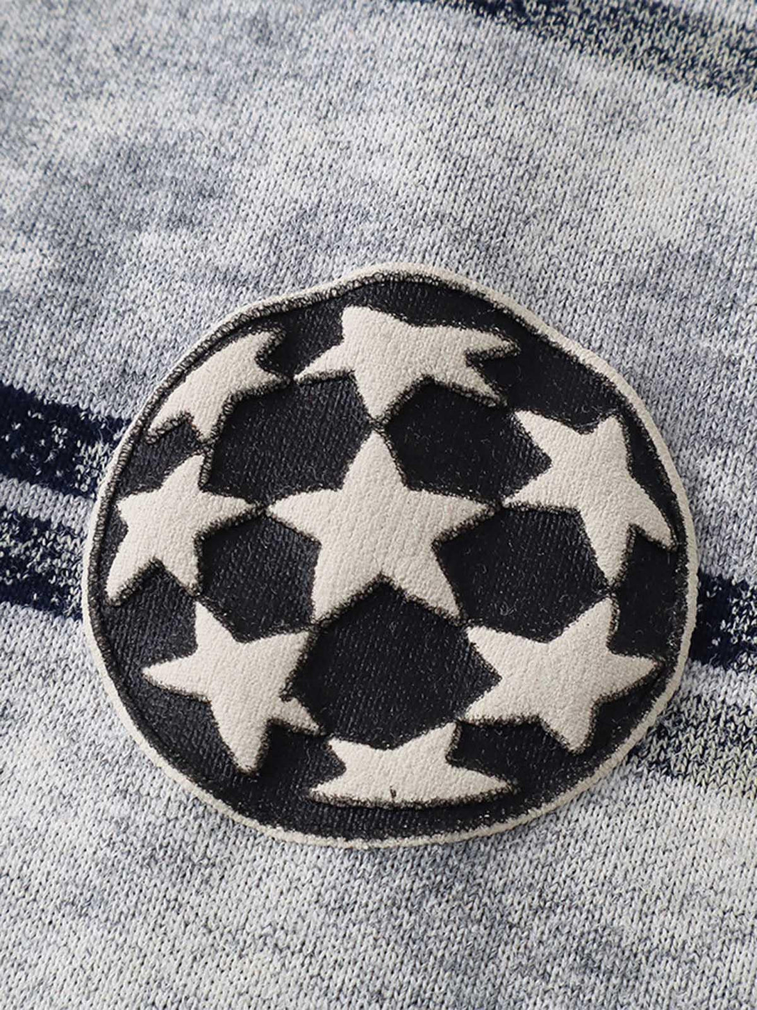 A detailed look at the star pattern patch on the striped T-shirt by TALISHKO.