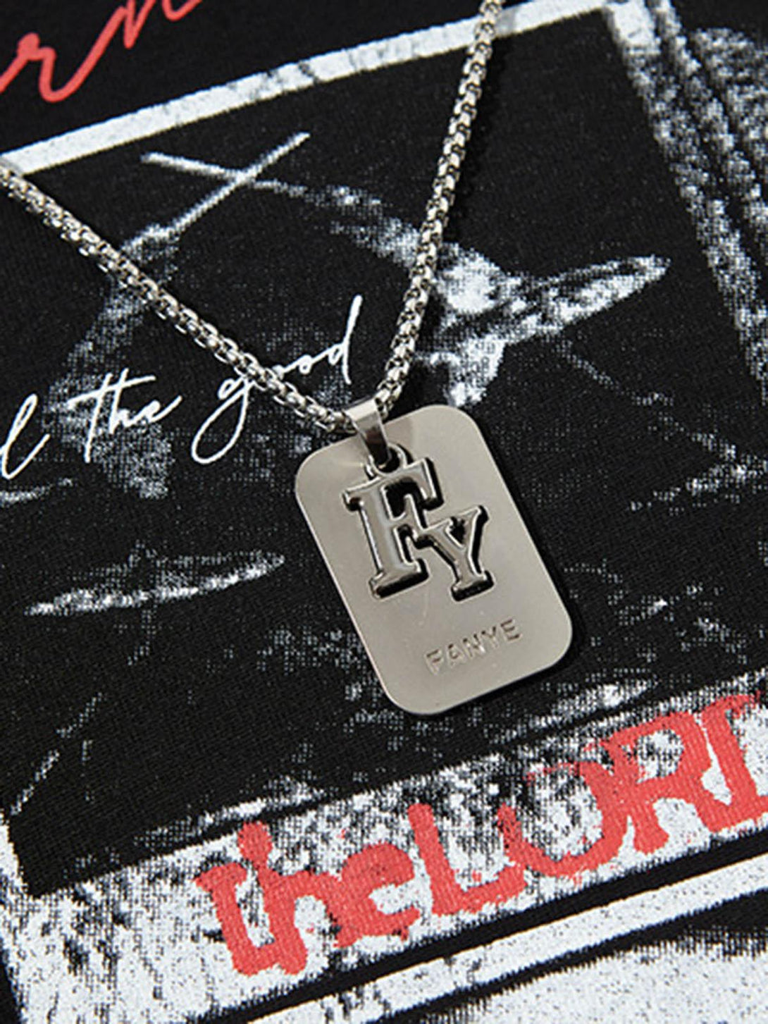 A zoomed-in view of a TALISHKO graphic vest featuring a rock-themed print and metal tag detail.