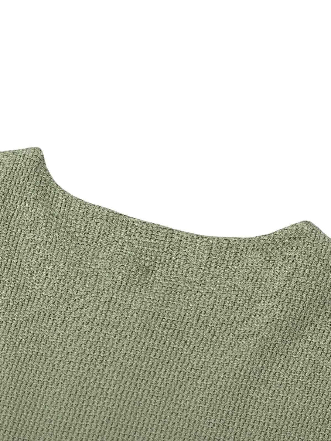 Zoomed-in texture of TALISHKO's knitted sweater in green, showcasing the intricate fabric detail.