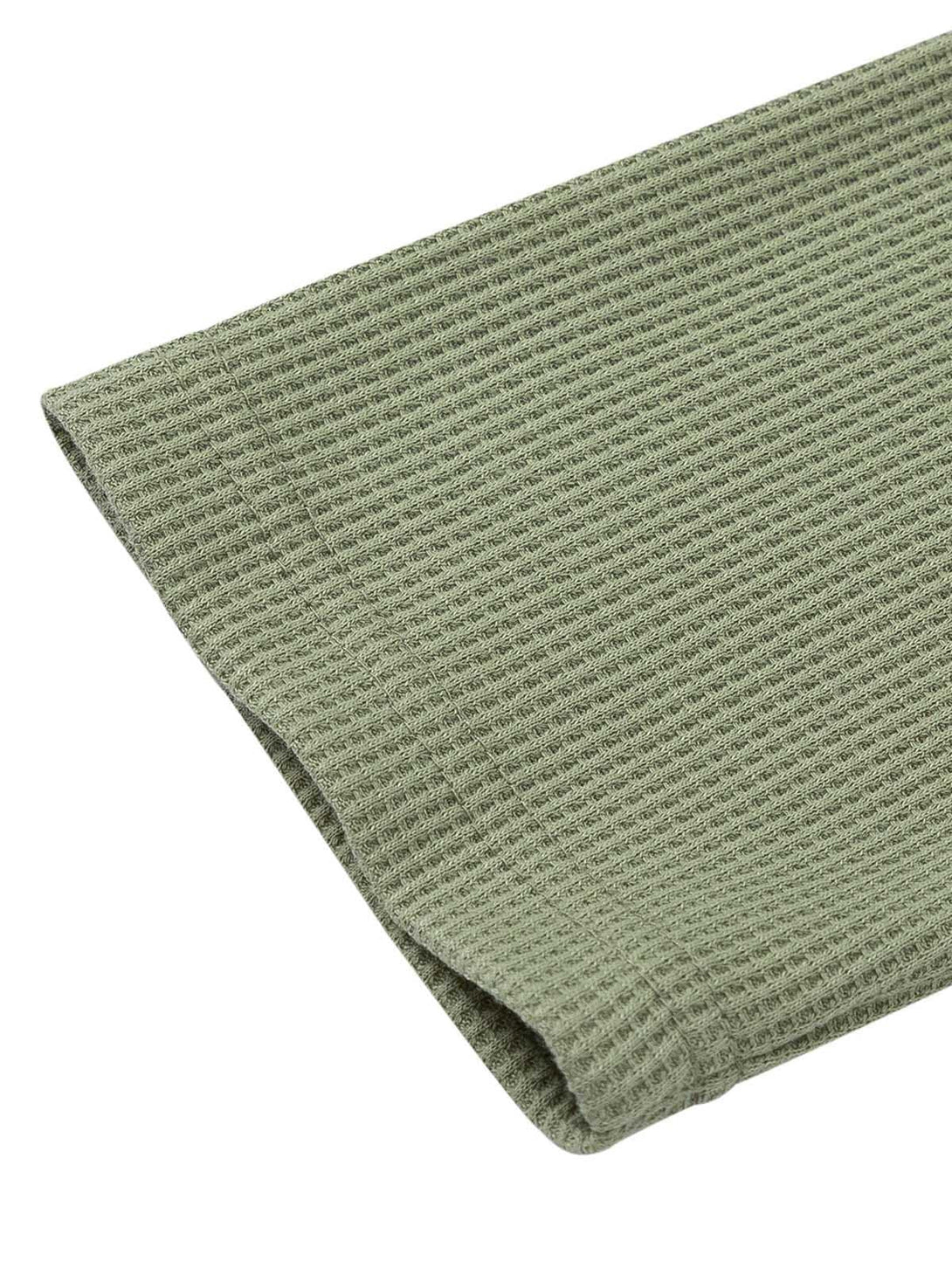 Intricate look at the green knit texture of TALISHKO's sweater, highlighting the fine details.