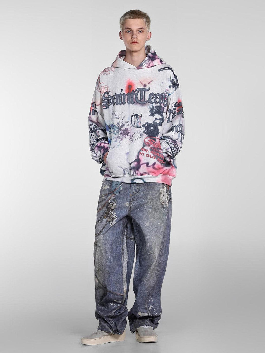 Model in TALISHKO graffiti hoodie and jeans, highlighting artistic streetwear style.