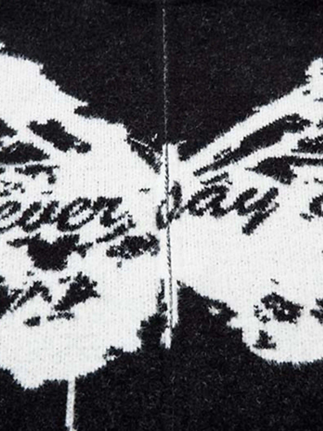 Intricate view of a TALISHKO cardigan's butterfly jacquard pattern with slogan detailing.