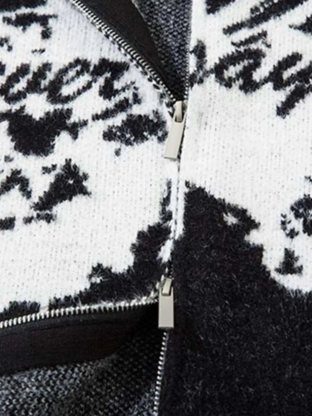 Intricate look at TALISHKO cardigan's zipper detail with bold butterfly and slogan jacquard.