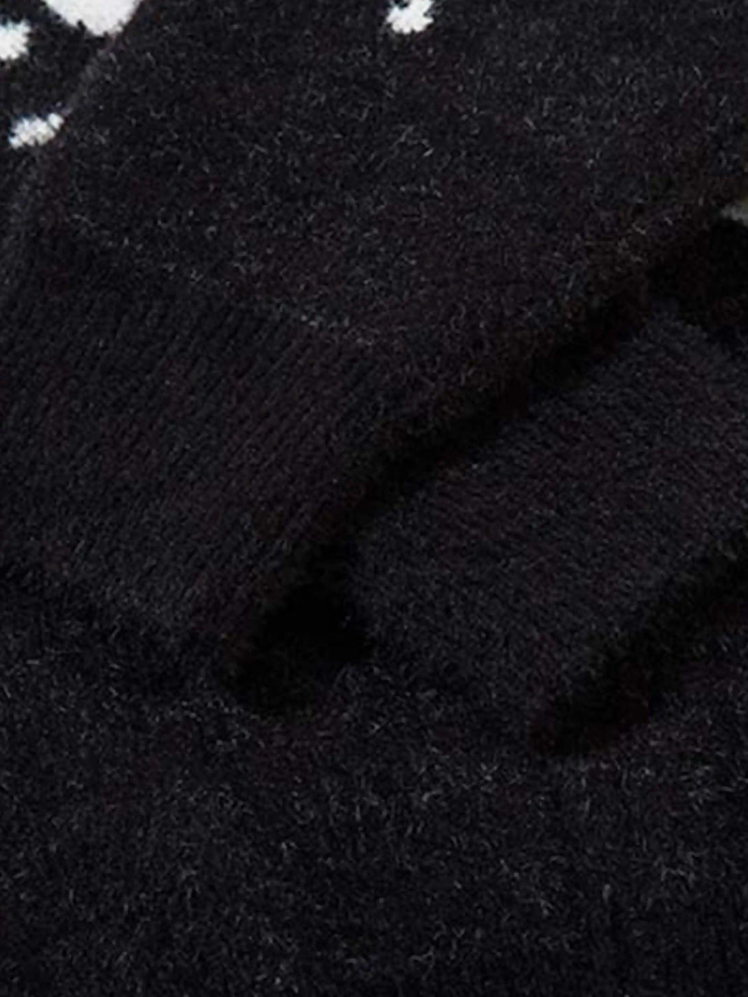 Detailed fabric and stitching of the TALISHKO cardigan highlighting its jacquard texture.