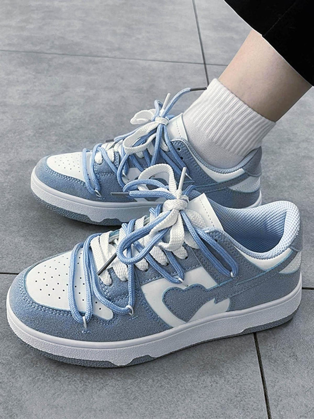 TALISHKO haze blue board shoes with heart detail and stylish laces, worn with white socks.