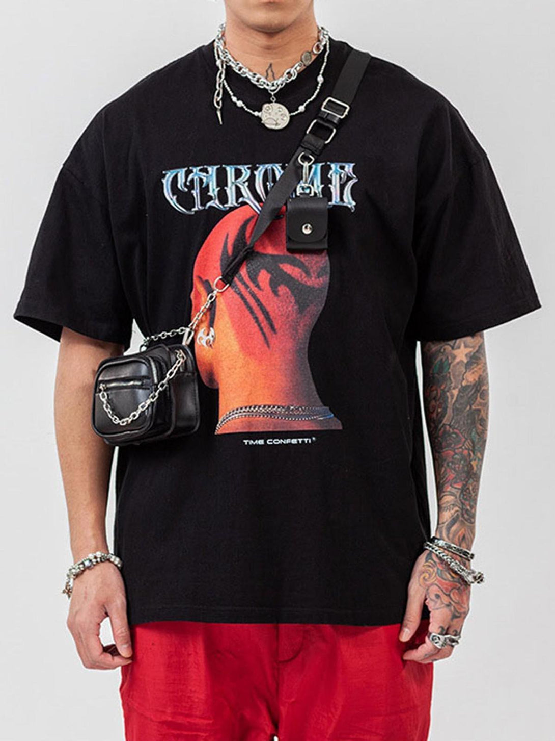 Model wearing TALISHKO hip hop T-shirt with bold head print and layered accessories.