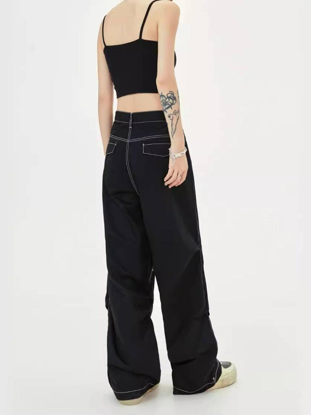 Model in TALISHKO jeans with heart rivets, multi-pockets, and contrast stitching, paired with a black crop top.