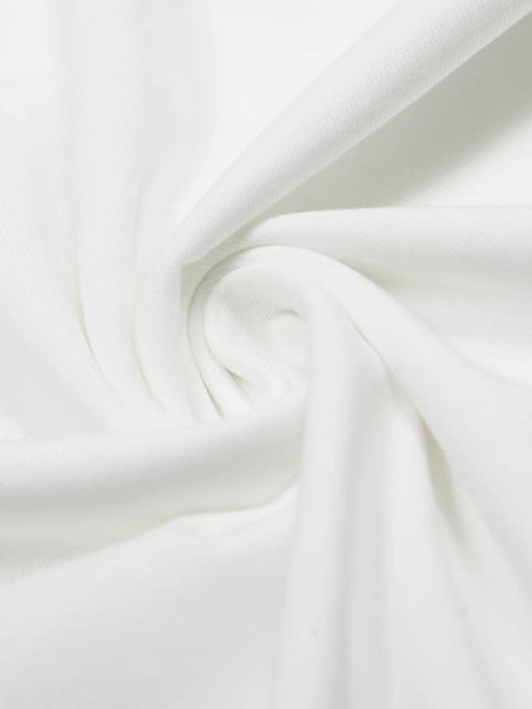 A close-up of the soft white fabric texture of the TALISHKO T-shirt.