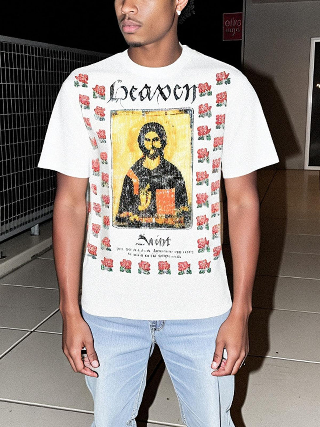 Model wearing TALISHKO T-shirt featuring floral graphics and a religious icon design.
