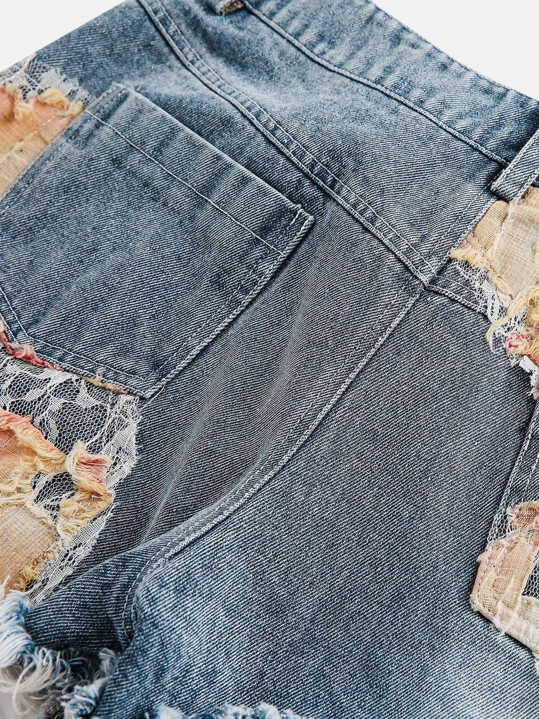Intricate craftsmanship on TALISHKO jorts, highlighting lace details and distressed accents.