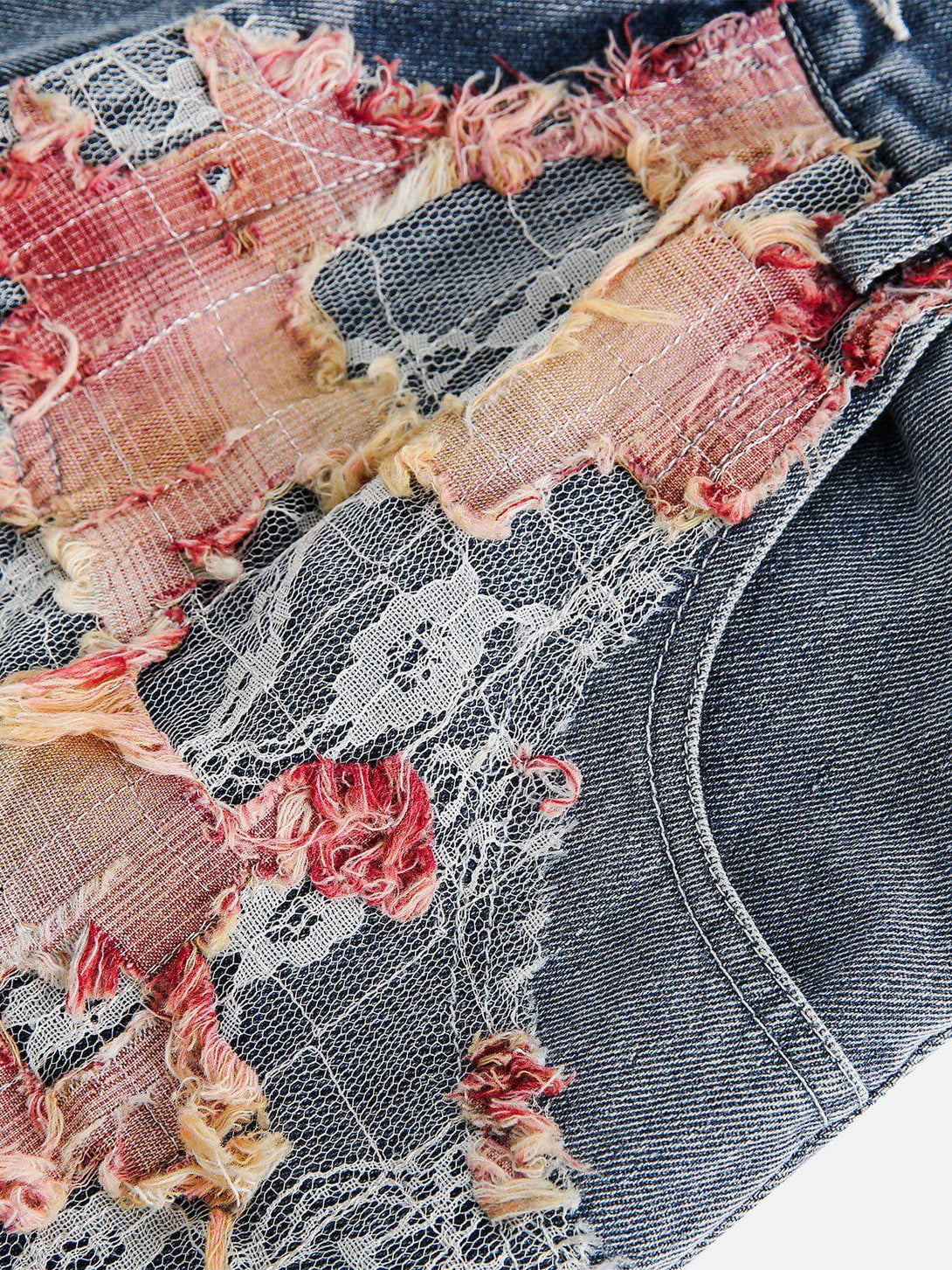 Intricate look at TALISHKO denim jorts with lace and distressed fabric details.
