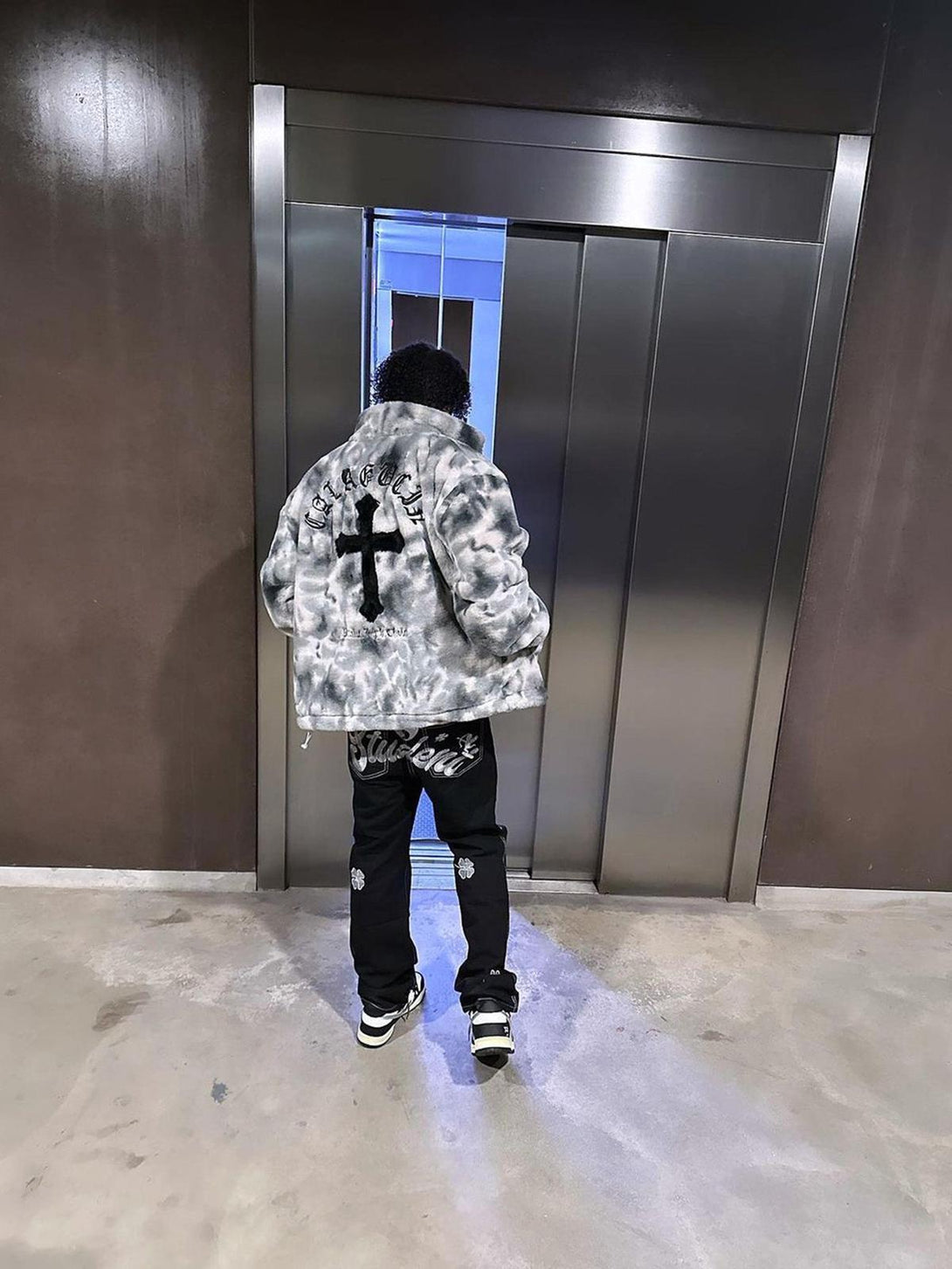 Back view of TALISHKO's urban tie-dye jacket in faux lambswool, paired with stylish black pants.