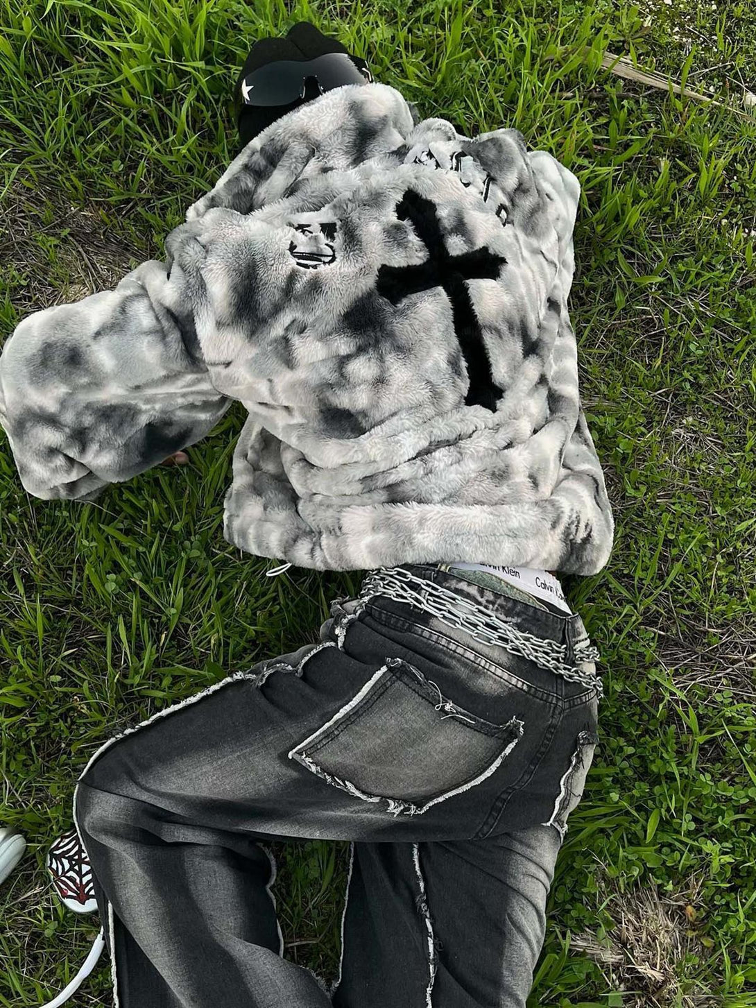 TALISHKO's tie-dye jacket in faux lambswool, styled casually on grass with urban flair.