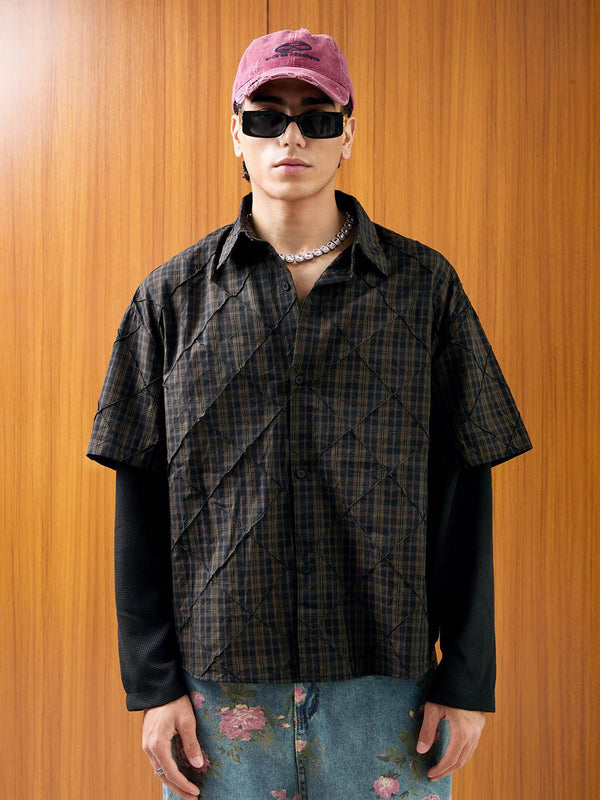 Model wearing a stylish plaid pleated polo shirt by TALISHKO, paired with floral denim and accessories.