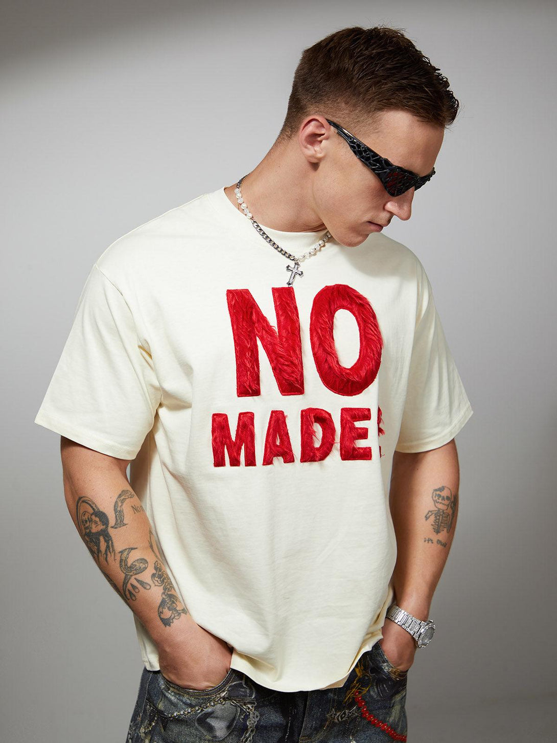 Model wearing a TALISHKO T-shirt with bold red embroidery, showcasing a retro-inspired look.