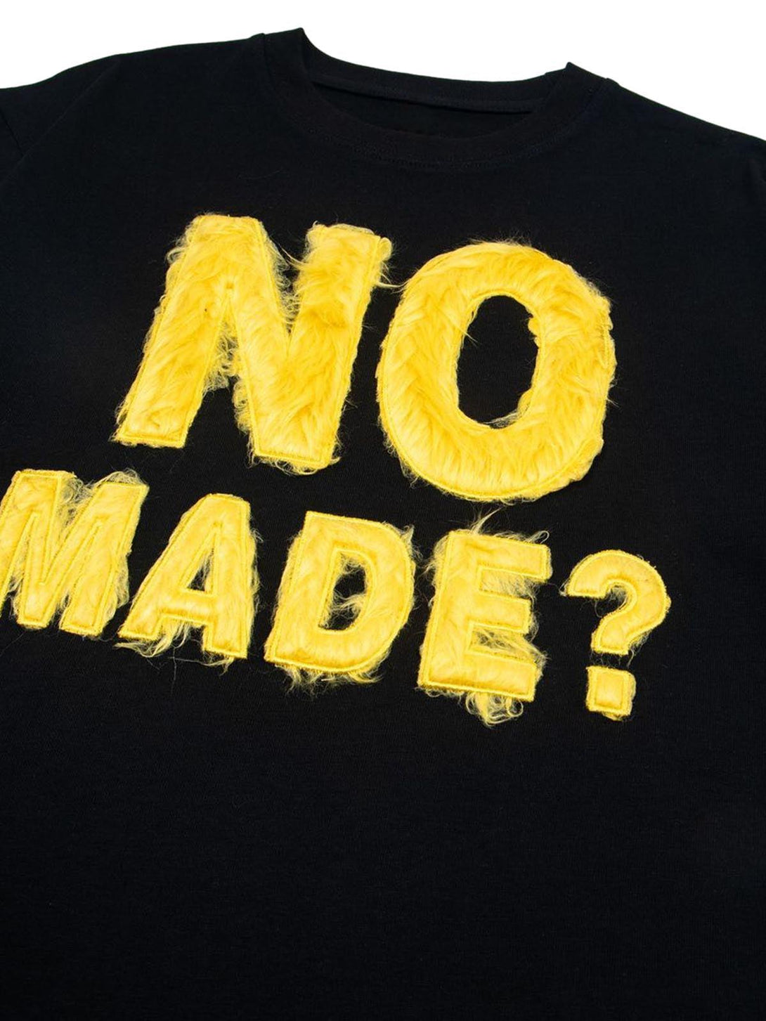 Fuzzy yellow embroidery detail on a black TALISHKO T-shirt, adding a retro and playful touch.