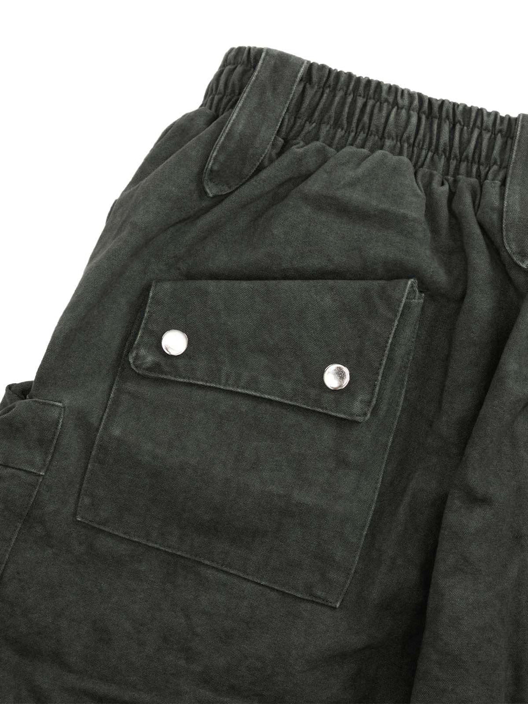 Elastic waistband and pocket detail of washed shorts by TALISHKO, showcasing rugged design.