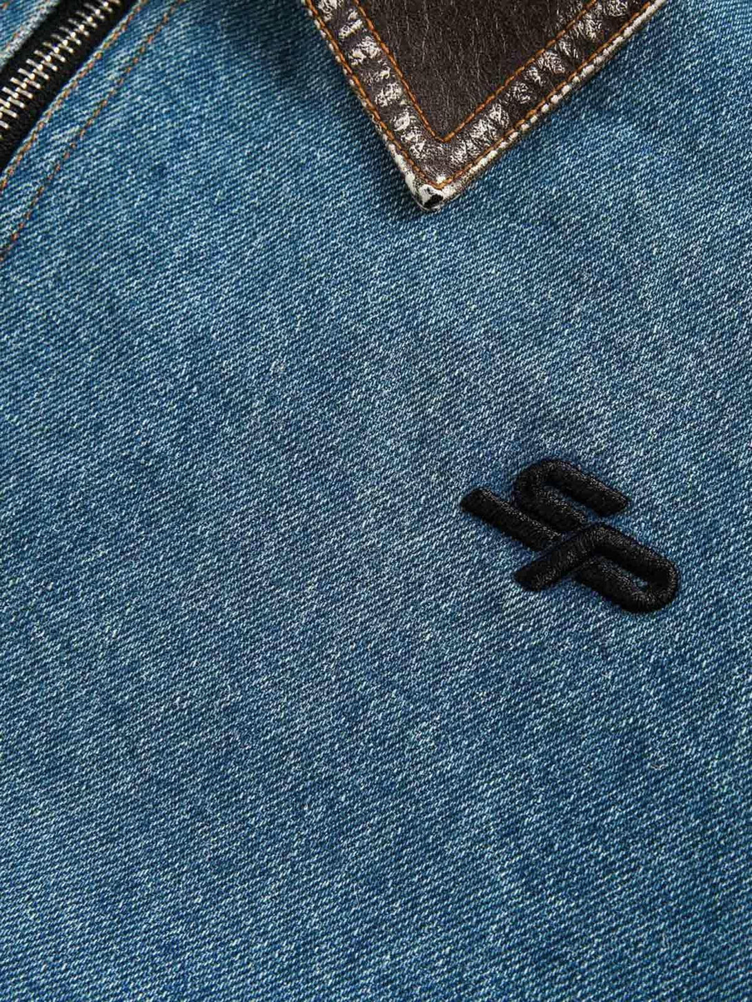 Zoomed-in texture of TALISHKO's denim work jacket, featuring detailed embroidery and stitching.