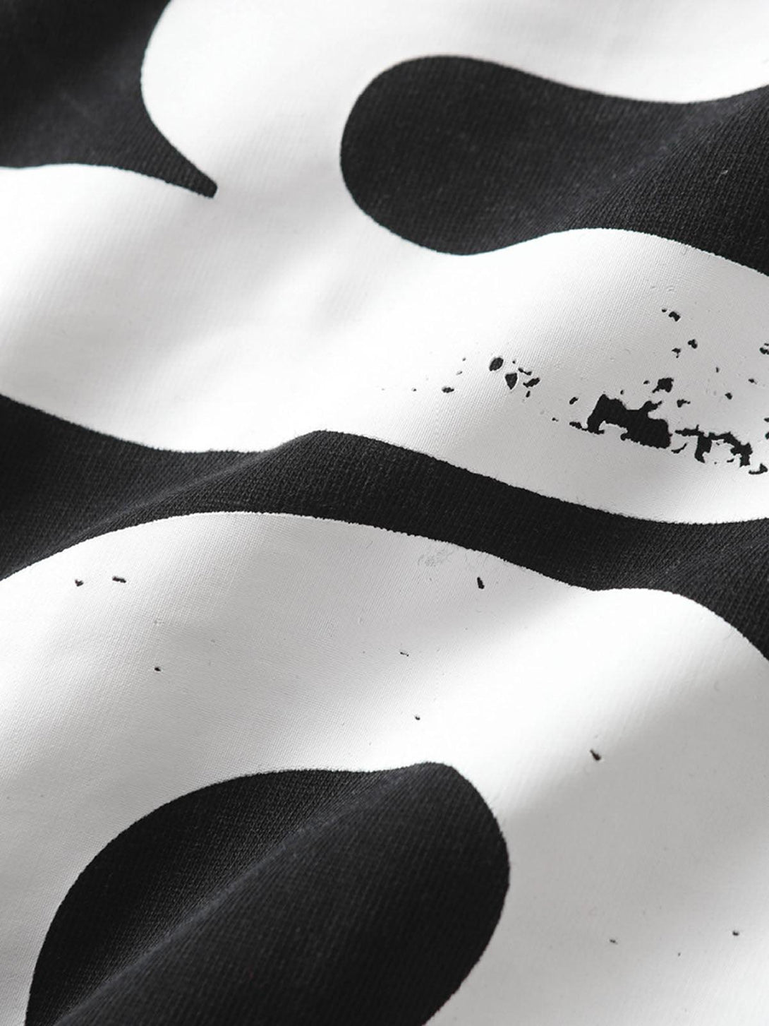 A detailed view of TALISHKO's T-shirt, highlighting the bold, distressed black and white print.