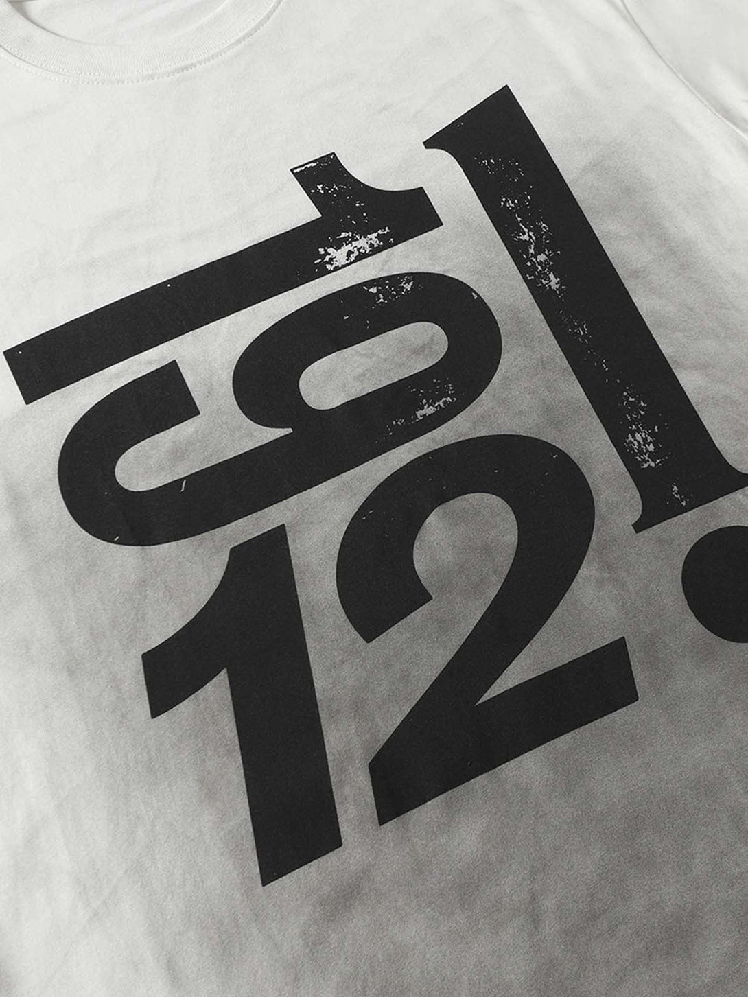 A close-up of TALISHKO's T-shirt, showcasing the bold, distressed print and textured design.