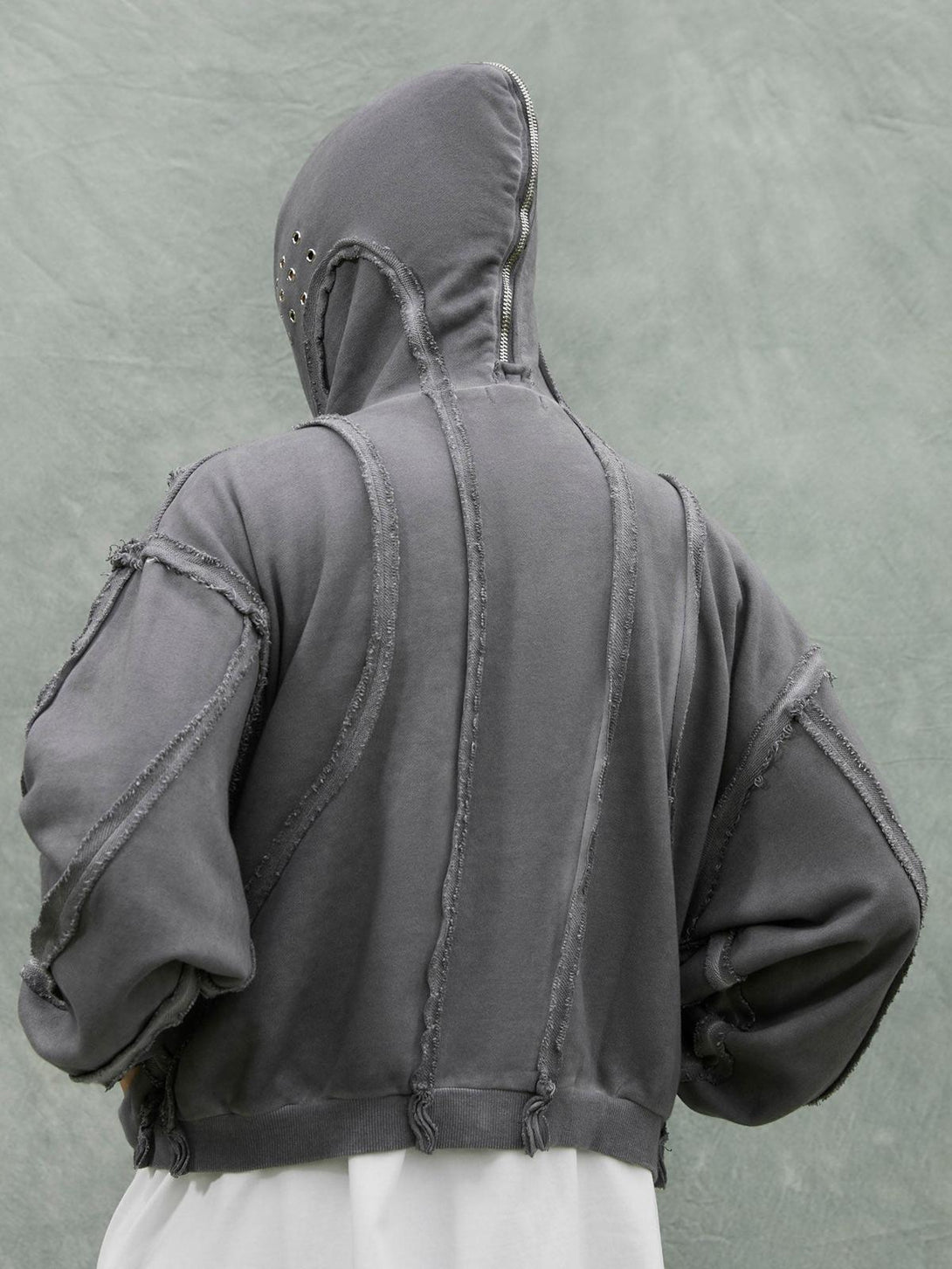 Back view of TALISHKO distressed full zip hoodie with unique seam details and eyelet accents.