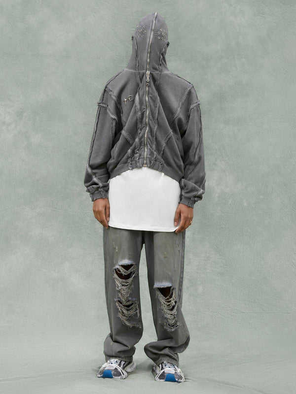 Model wearing TALISHKO distressed full zip hoodie and pants, showcasing a rugged street style.