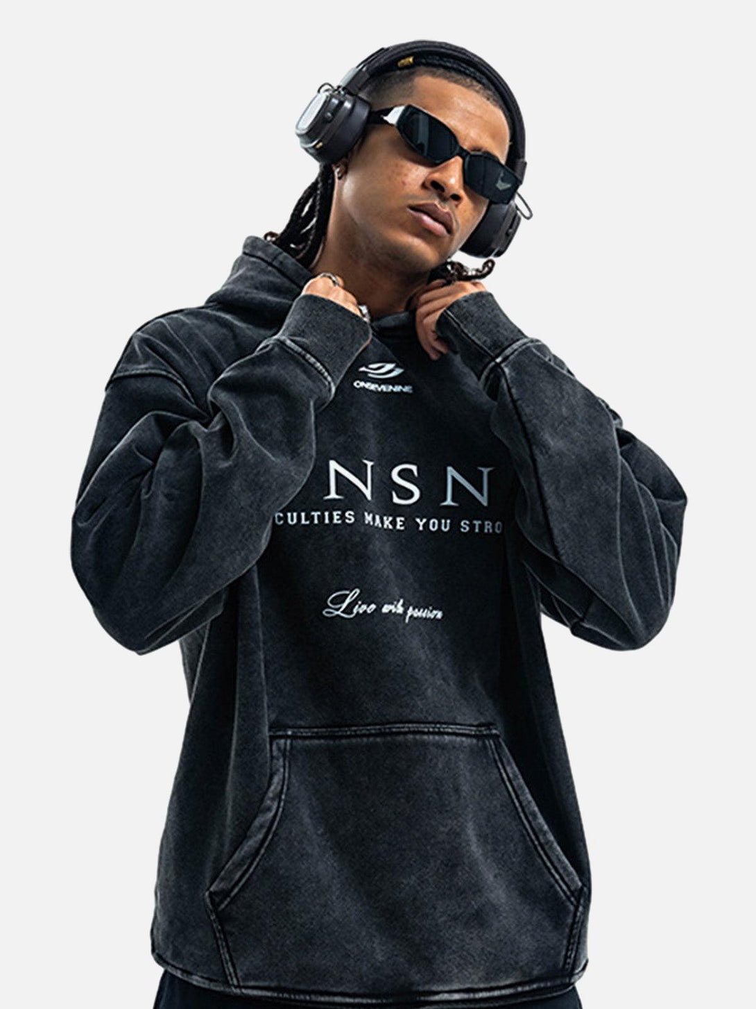 Model wearing a heavy washed fleece hoodie by TALISHKO, styled with sunglasses and headphones.