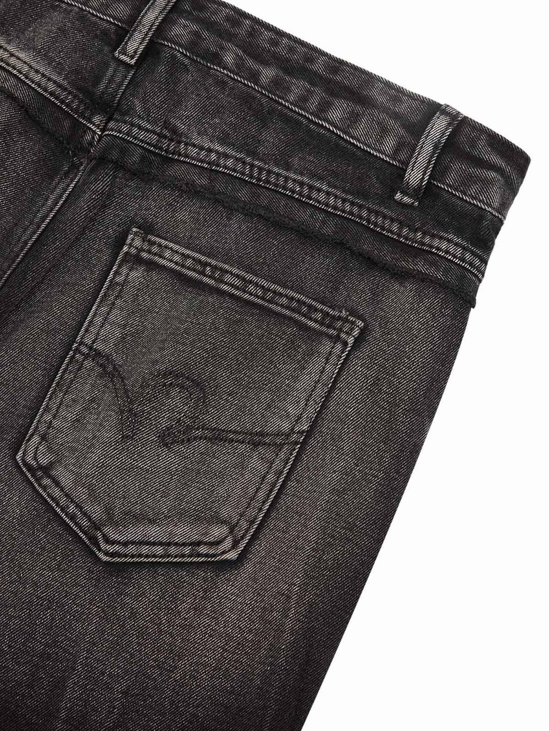 A detailed view of TALISHKO jeans highlighting the back pocket and intricate stitching design.