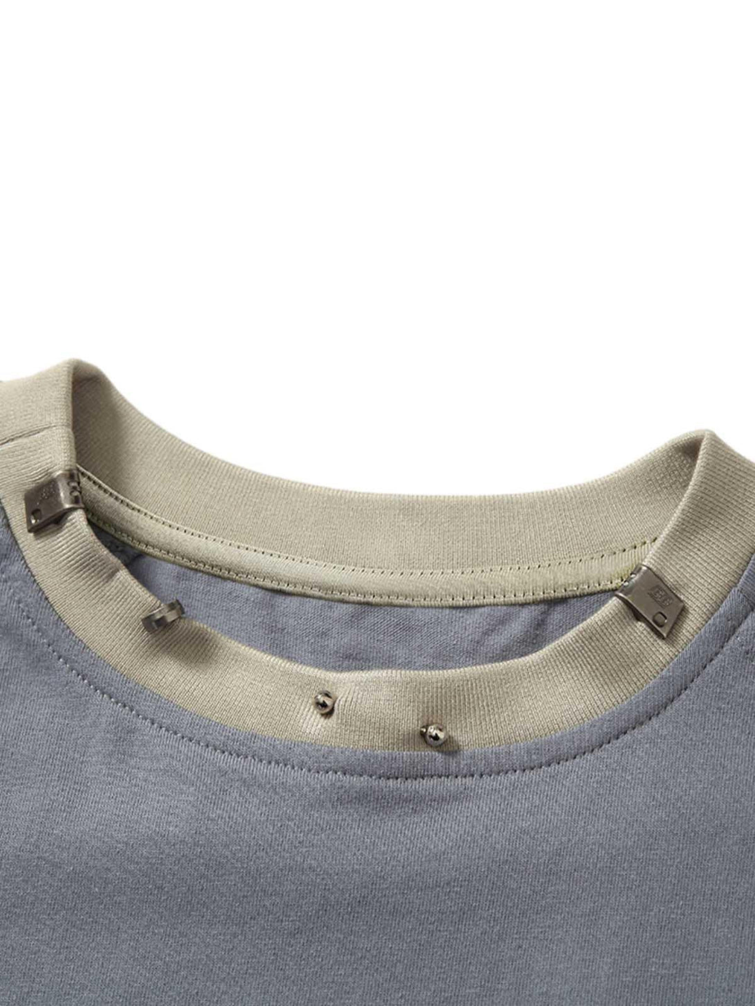 A closer look at TALISHKO's metal collar detail on a heavy washed T-shirt, showcasing craftsmanship.