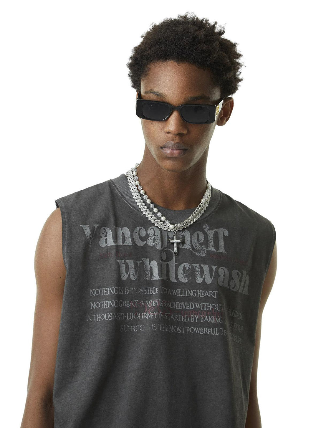 Model wearing TALISHKO's washed gray vest with retro typography, accessorized with bold necklaces.