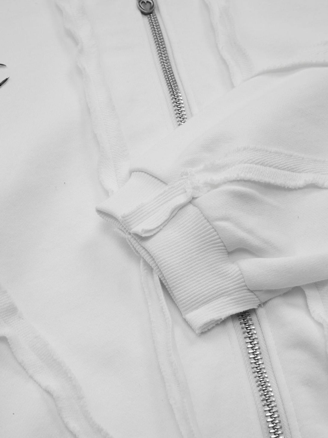 Detailed fabric and zipper of a white distressed hoodie by TALISHKO.