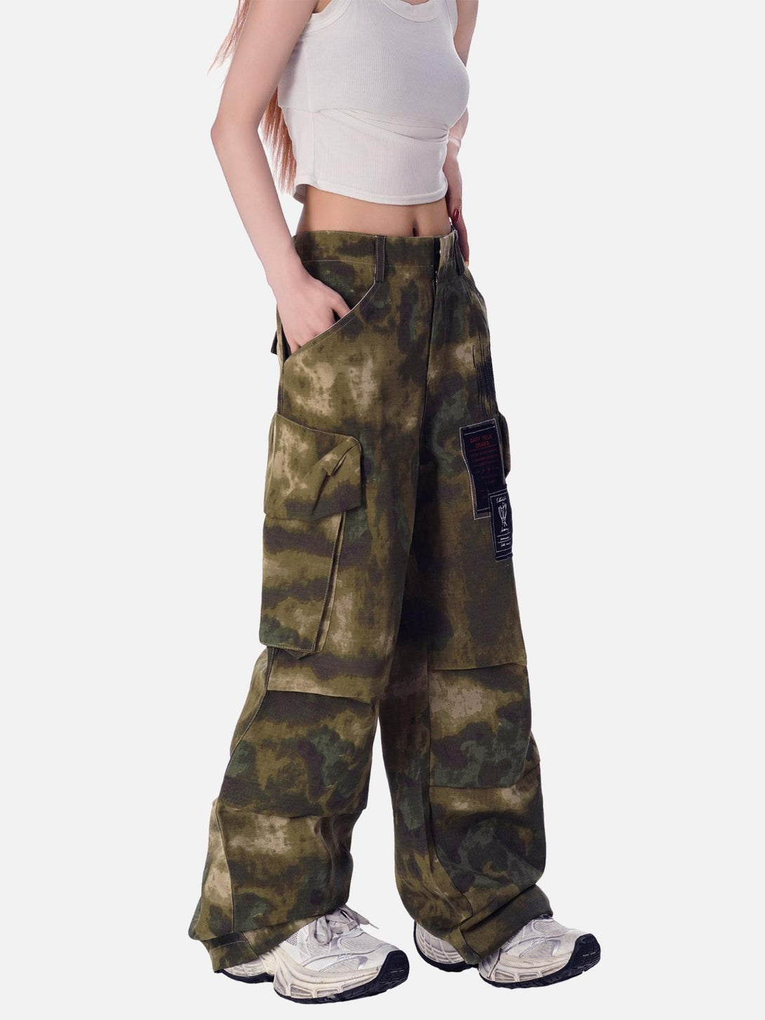 Model wearing TALISHKO camouflage pants with a relaxed fit and multiple pockets for utility.