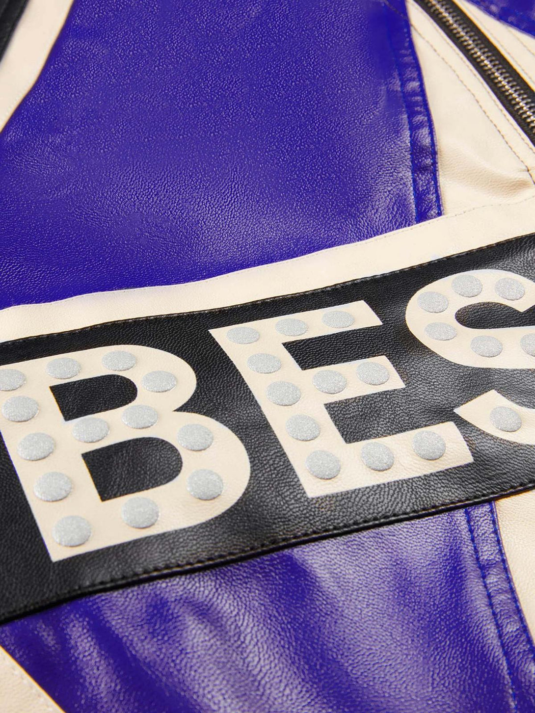 A tight crop highlighting TALISHKO's biker jacket, showcasing bold lettering and textured leather.