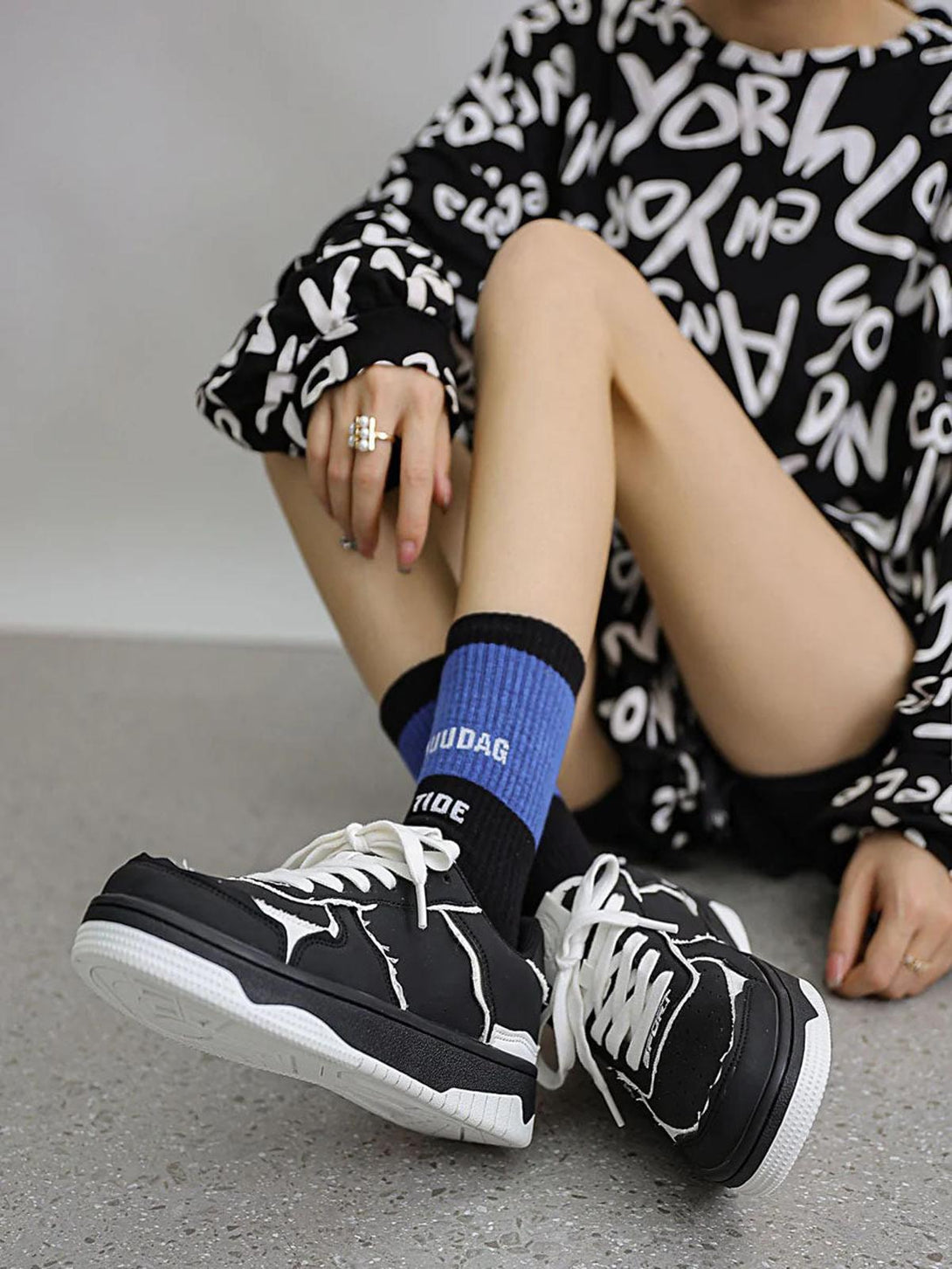 TALISHKO black and white casual shoes paired with graphic socks and a bold print outfit.