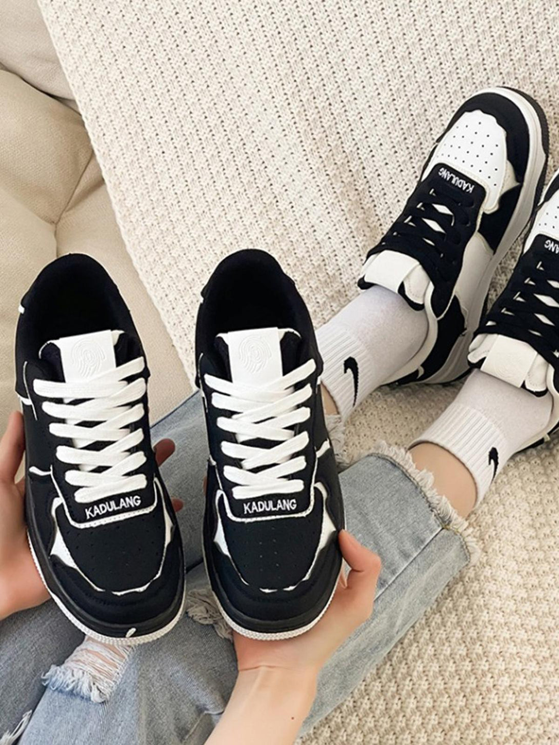 Casual black and white shoes by TALISHKO, styled with denim for a chic, relaxed look.