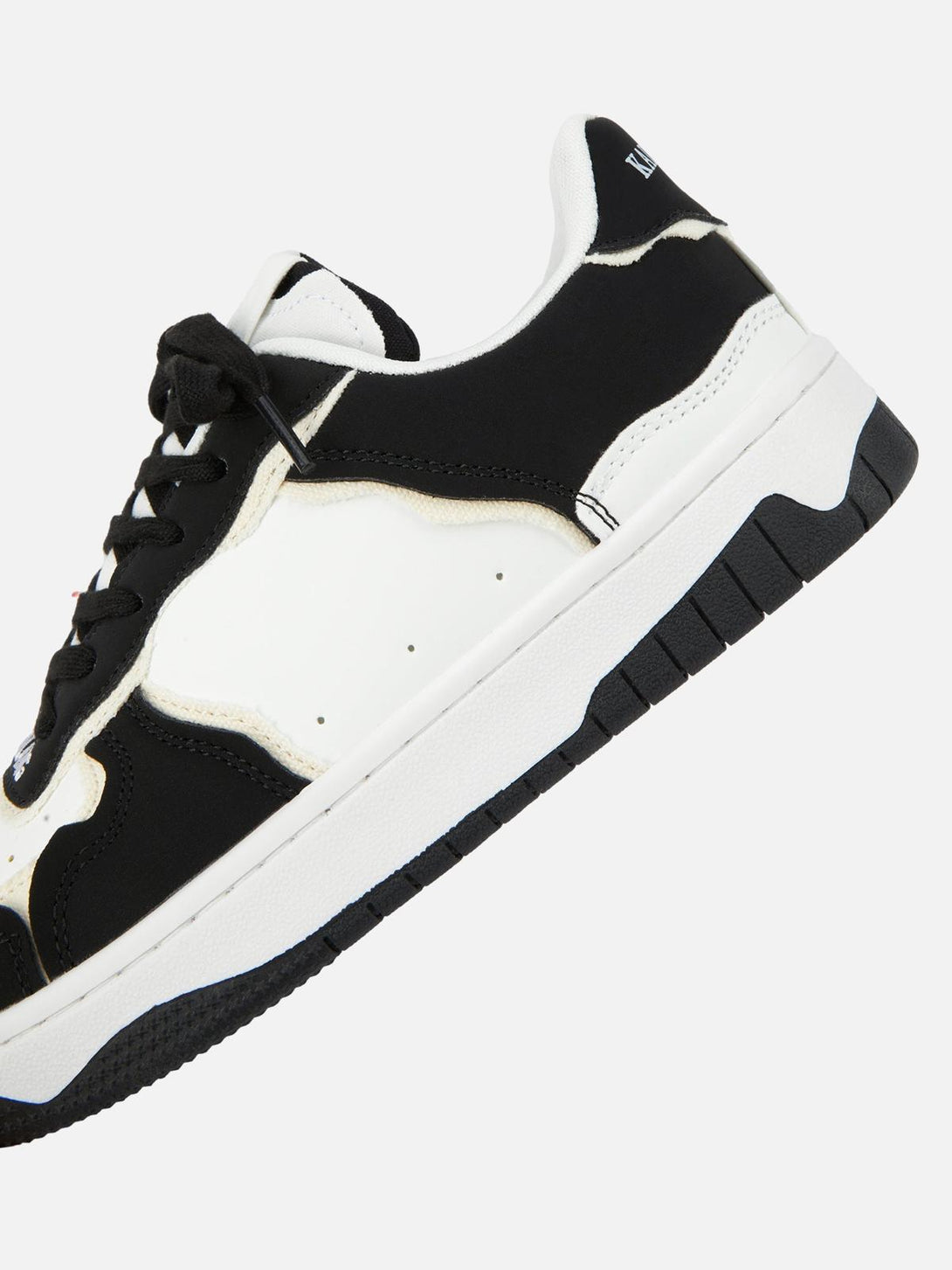 A close-up of TALISHKO's black and white casual shoe, highlighting its sleek side profile.