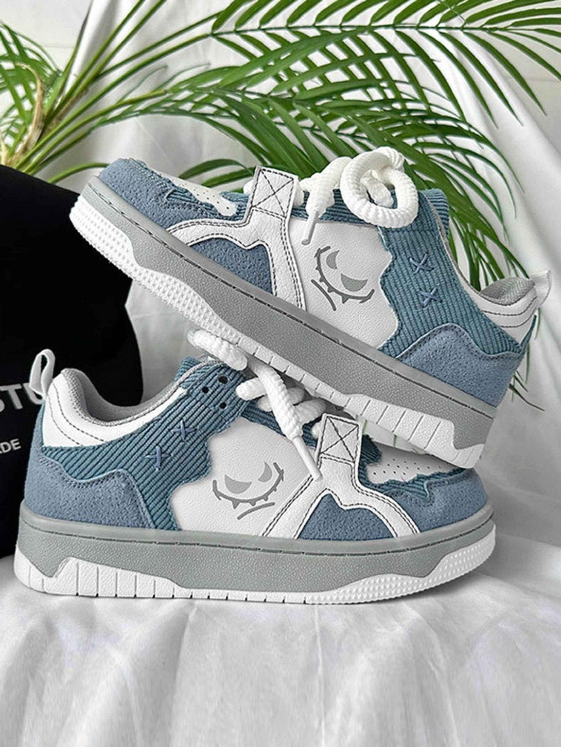 TALISHKO board shoes in blue and white, highlighting thick soles and unique graphic design.