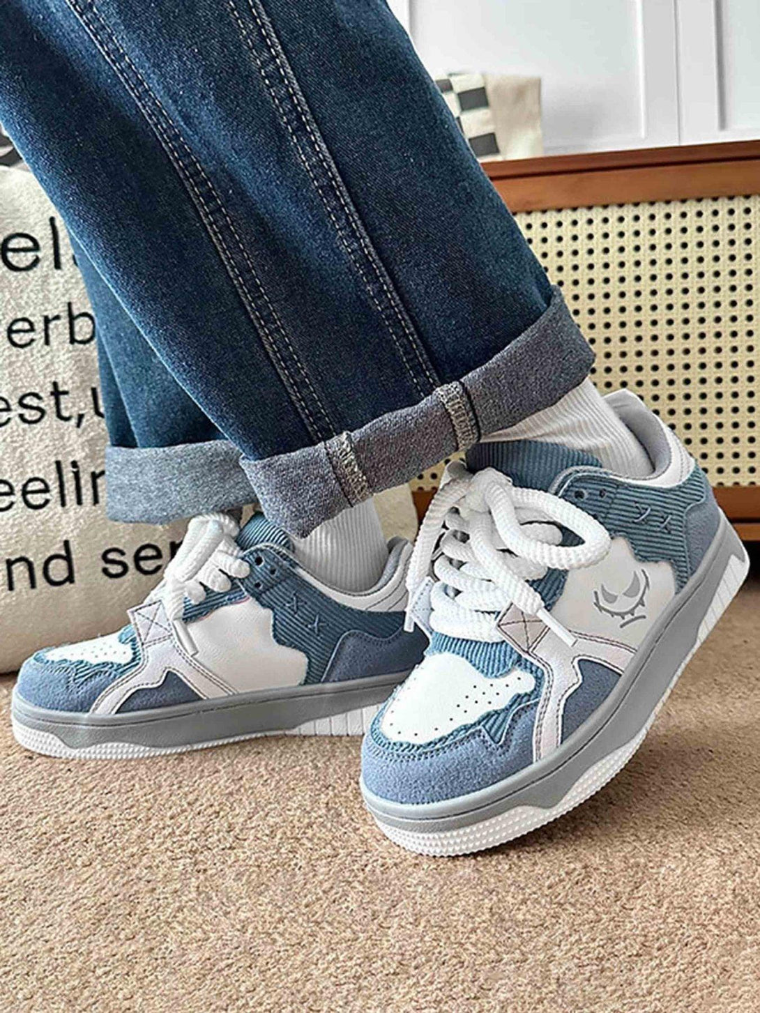 TALISHKO board shoes in blue and white paired with cuffed jeans, showcasing a casual style.