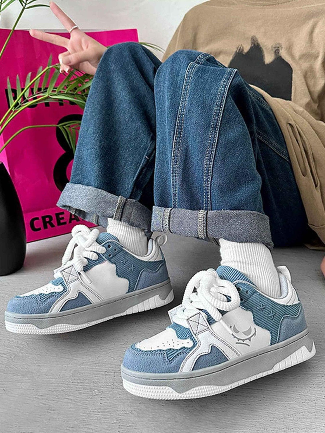 TALISHKO board shoes featuring a stylish blue and white design, paired with cuffed jeans.