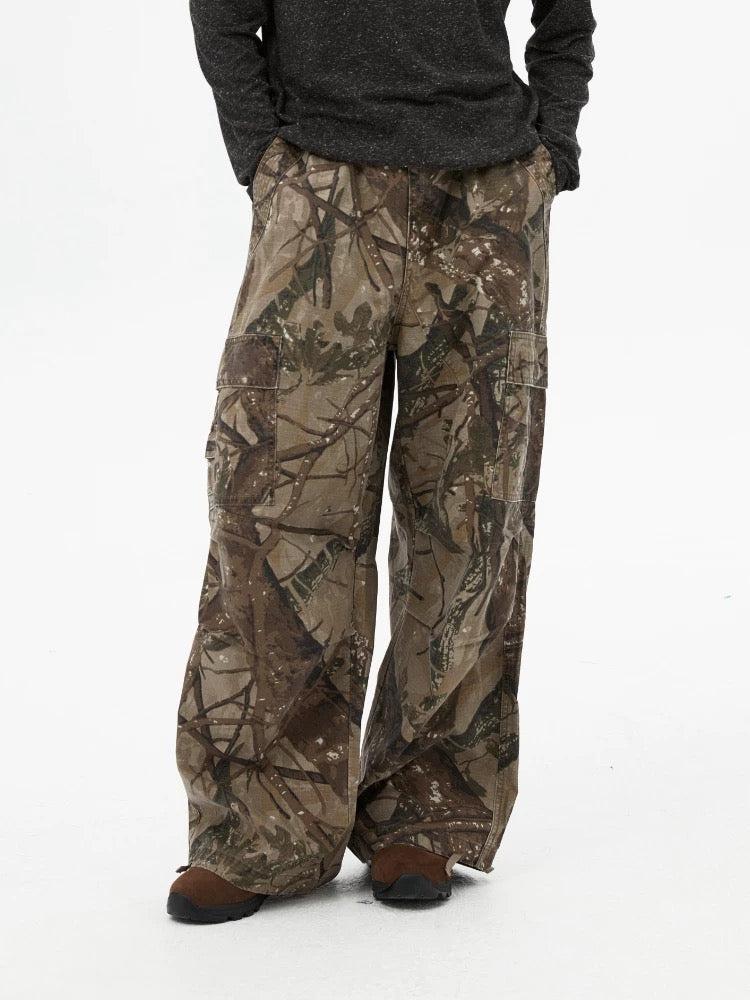 Model wearing TALISHKO camouflage pants paired with a dark top, highlighting casual style.