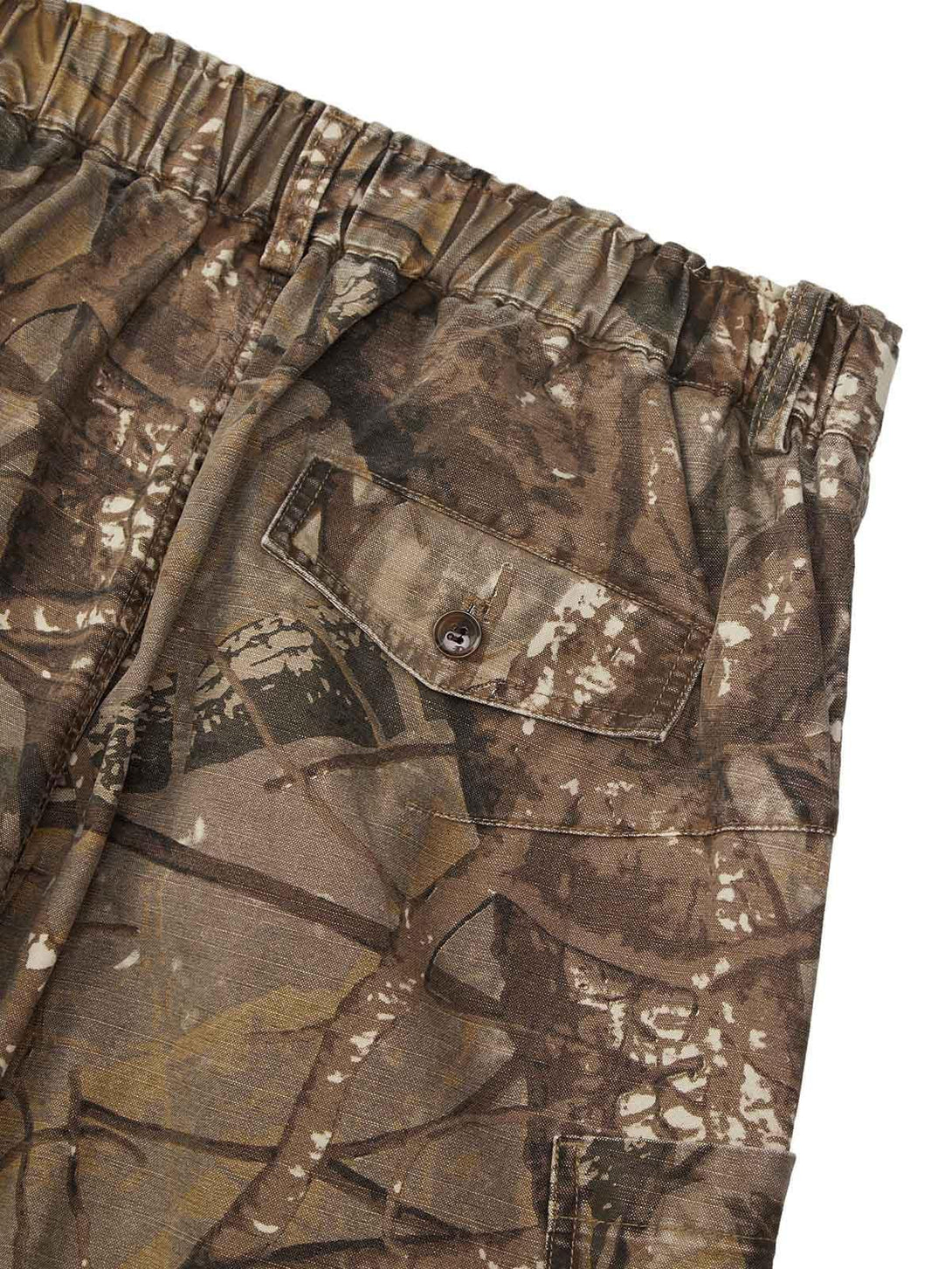 A detailed view of TALISHKO camouflage pants, highlighting the buttoned pocket and elastic waist.