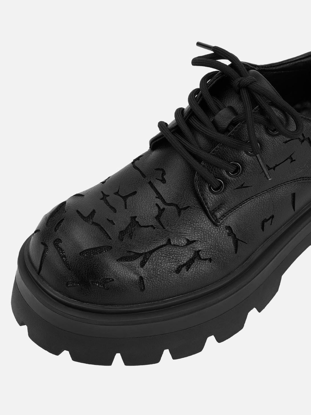A close-up of TALISHKO crackle leather shoes highlights textured details and chunky soles.