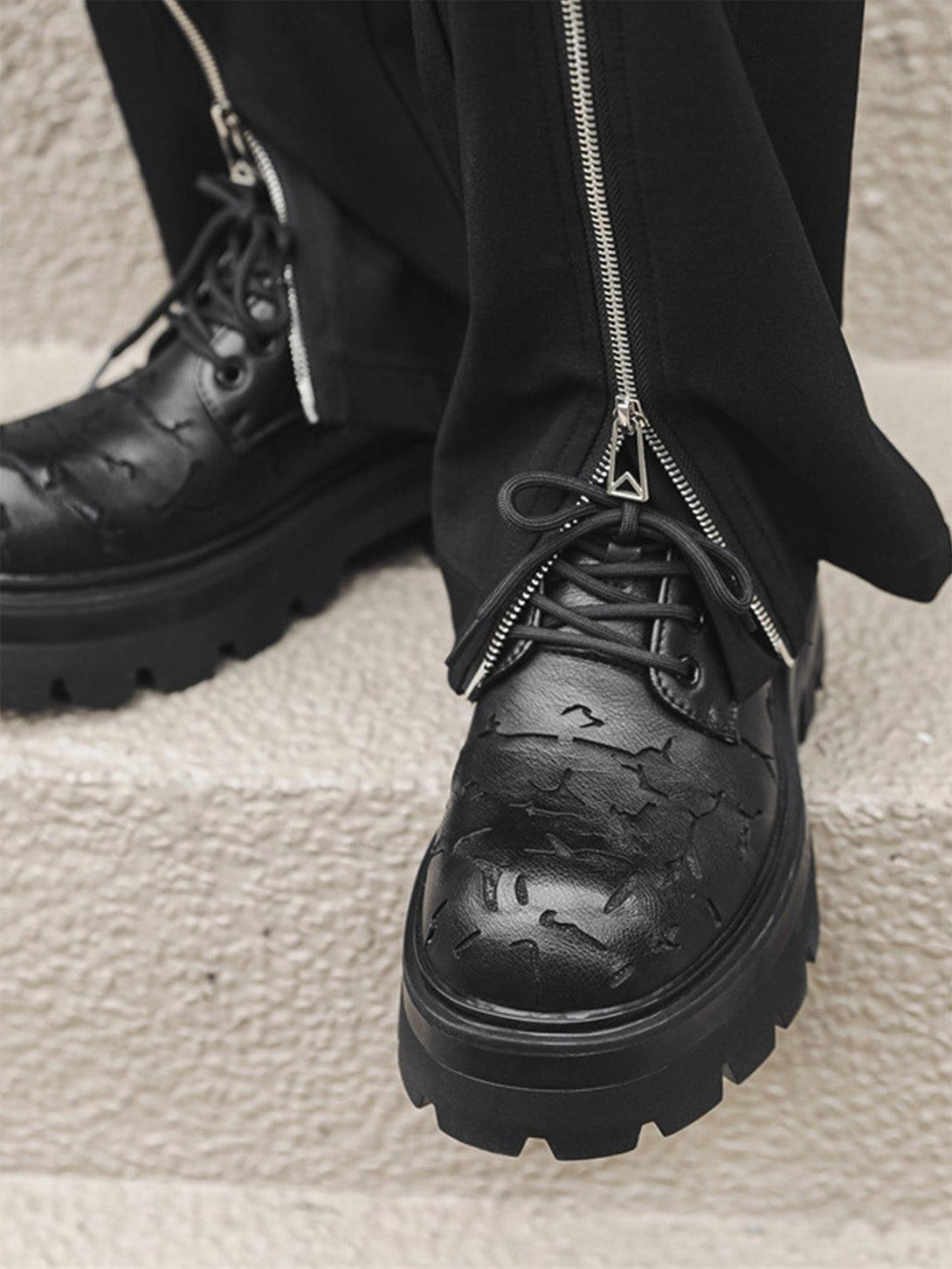 Detailed view of TALISHKO crackle leather shoes with textured design and chunky soles.