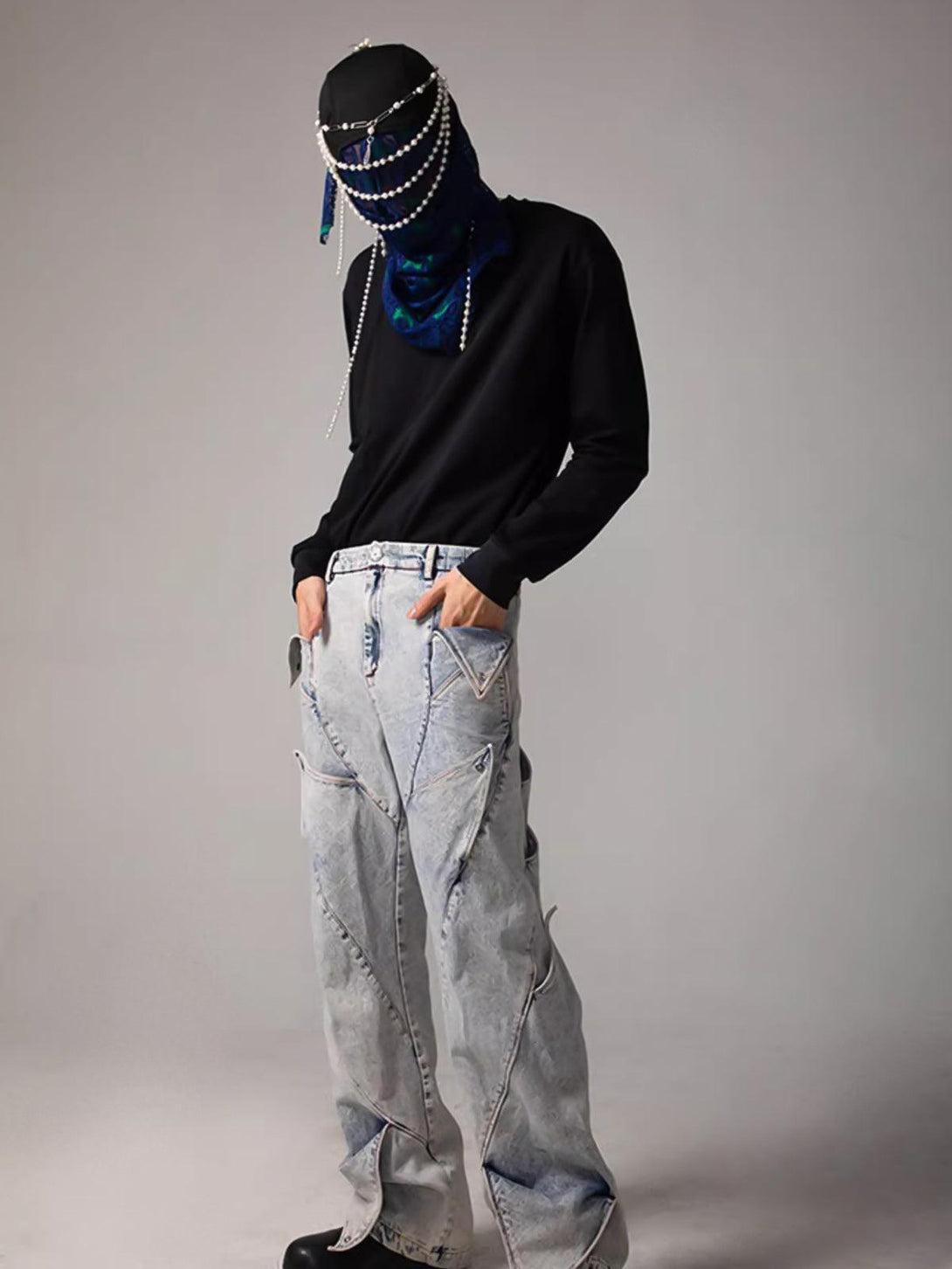 Model wearing TALISHKO deconstructed jeans and black top, showcasing avant-garde street style.