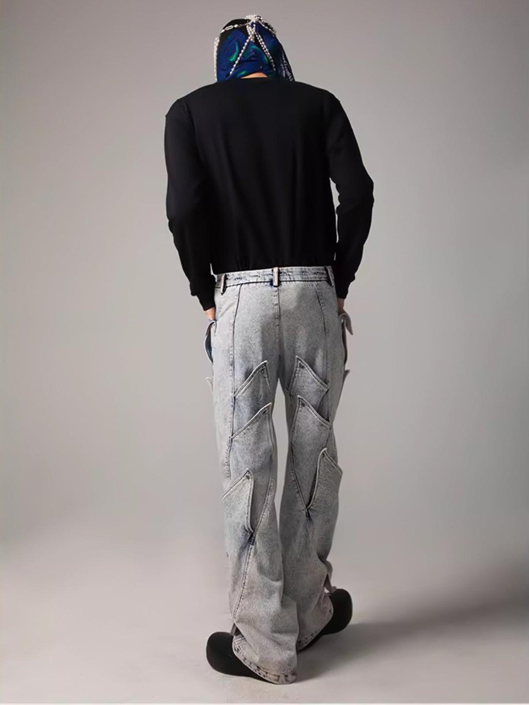 Back view of TALISHKO deconstructed jeans with unique geometric patterns and urban style.